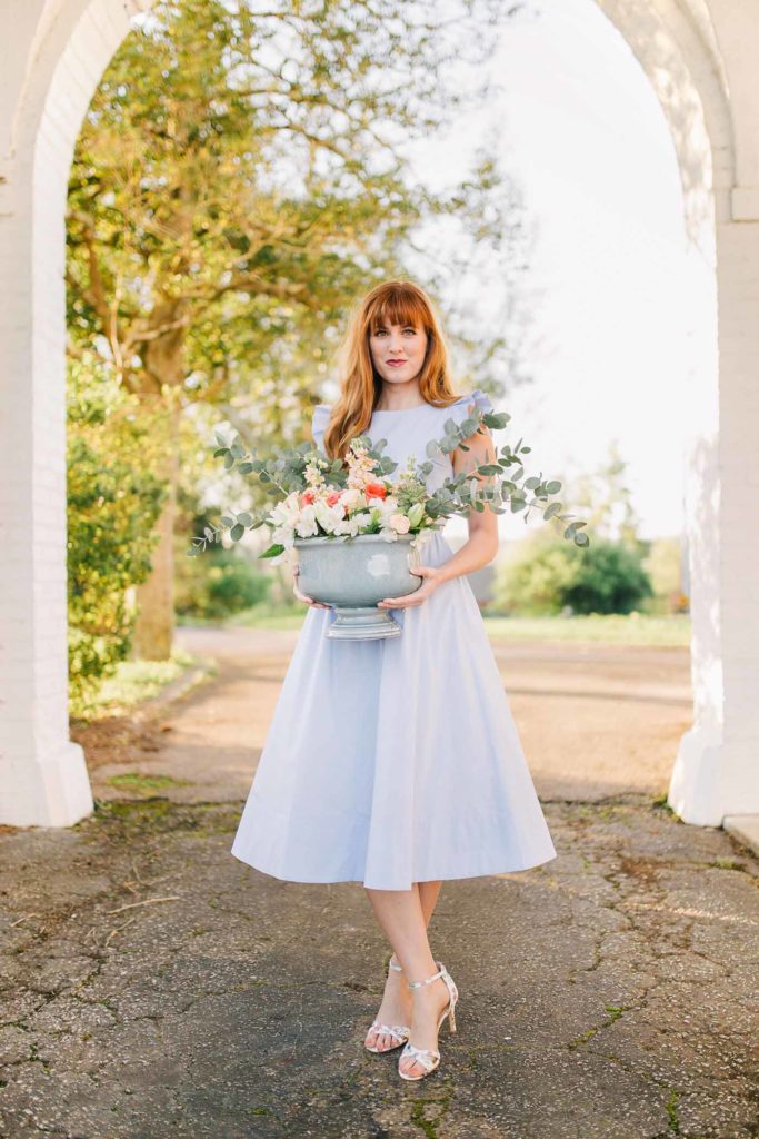 Spring floral arrangement with blue vase, eucalyptus, white stock, peach roses