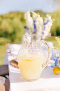blue, white, and yellow tables cape with homemade lemonade in a glass pitcher